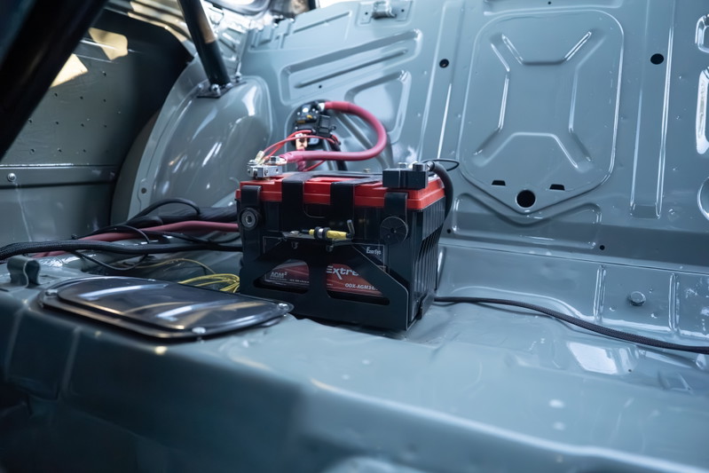 1989 BMW 325is with an aftermarket battery and wiring in the rear.