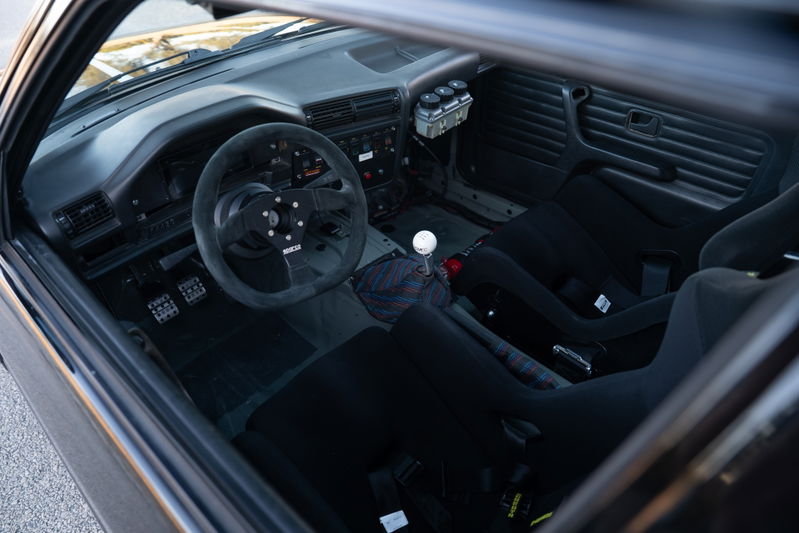 1989 BMW 325is LS1 interior: black racing seats, Sparco wheel, and shift knob.