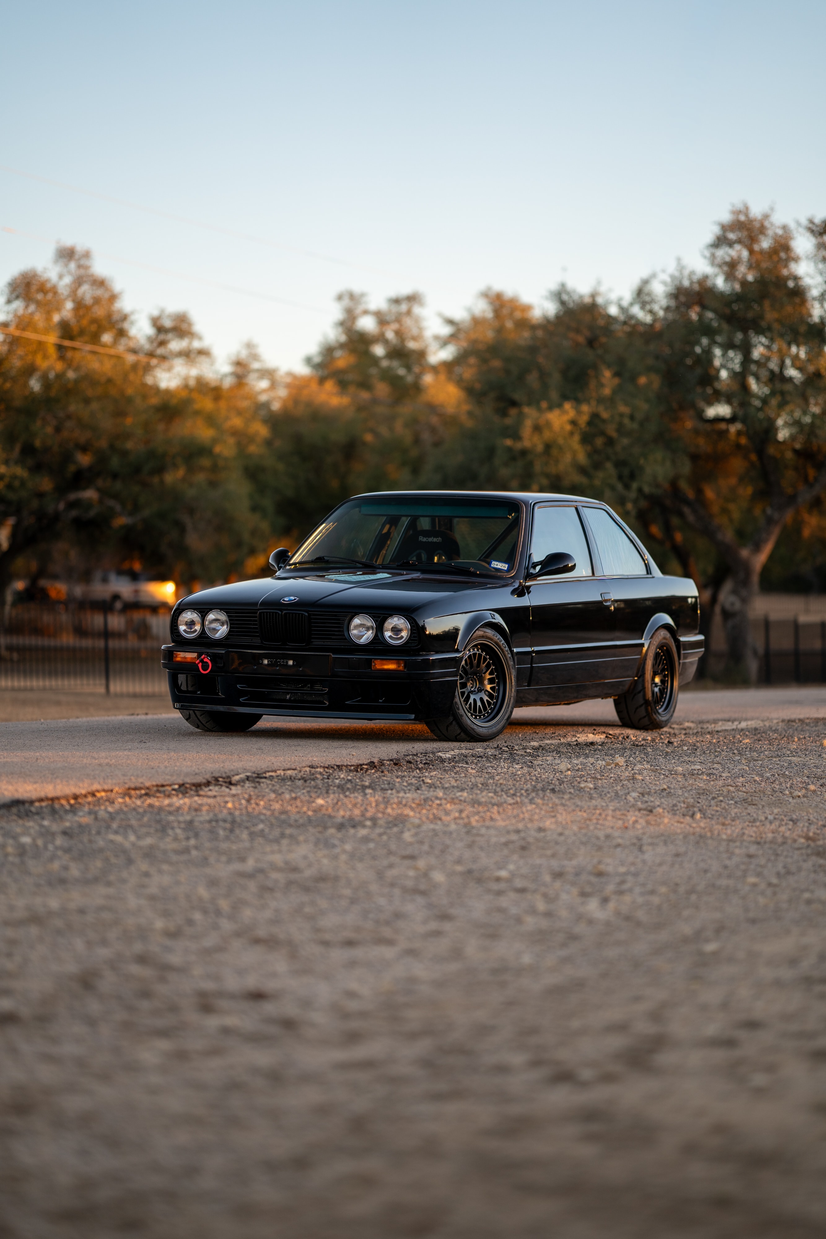 Black 1989 BMW 325is LS1 with mesh rims and red tow hook.