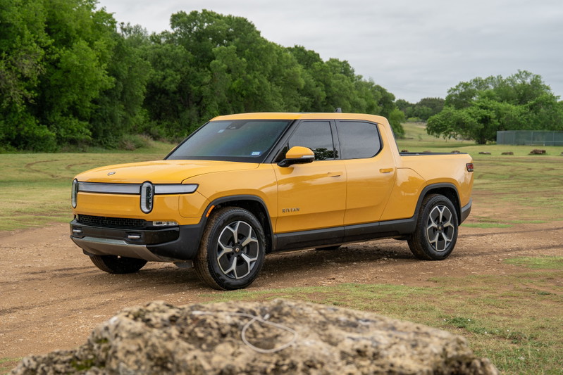 Yellow 2022 Rivian R1T electric pickup truck with alloy rims and black trim.