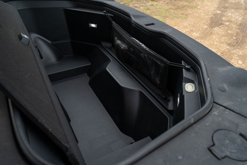 Rivian R1T electric pickup truck frunk interior with storage net and lighting.
