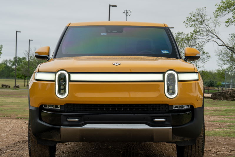Front view of a yellow 2022 Rivian R1T electric pickup truck with unique oval LED headlights.