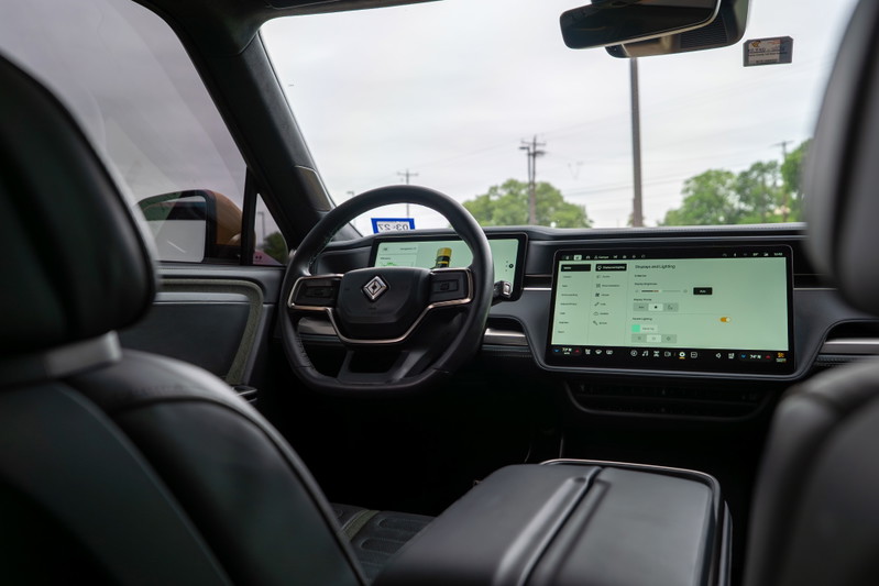 Interior of a yellow 2022 Rivian R1T showing the dashboard, steering wheel, and large infotainment screen.