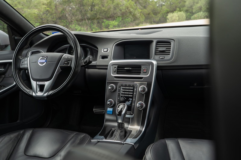 Interior of a 2015 Volvo V60 R-Design Polestar, black leather seats, silver trim.