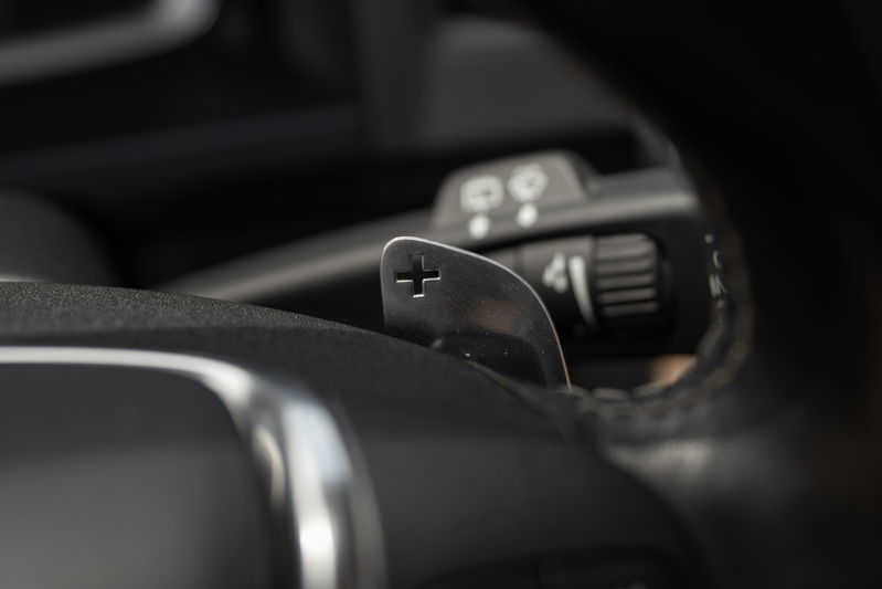 Close-up of metal paddle shifters on a 2015 Volvo V60 R-Design Polestar steering wheel.