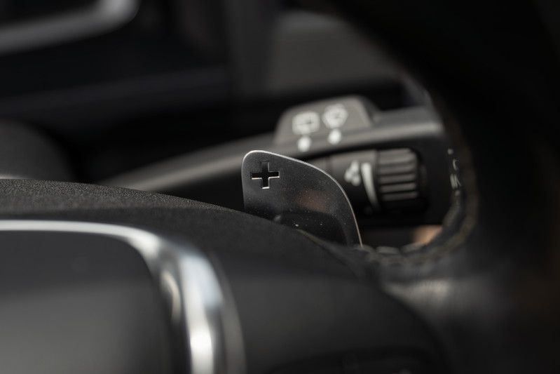 Close-up of metal paddle shifters on a 2015 Volvo V60 R-Design Polestar steering wheel.