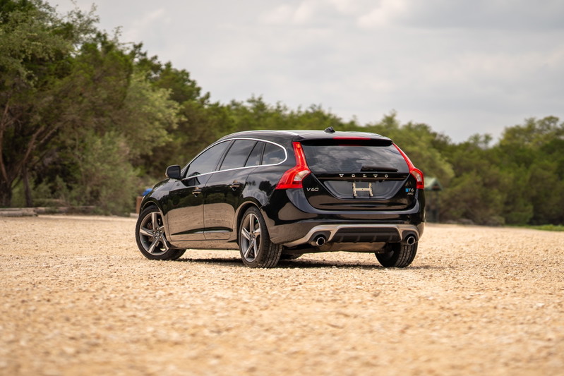 Black 2015 Volvo V60 R-Design Polestar with silver rims and dual exhaust.