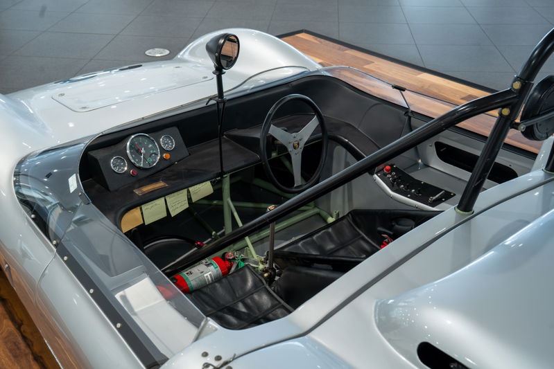1964 Elva Porsche 4-Cam race car cockpit with vintage gauges, roll bar, and racing seat.