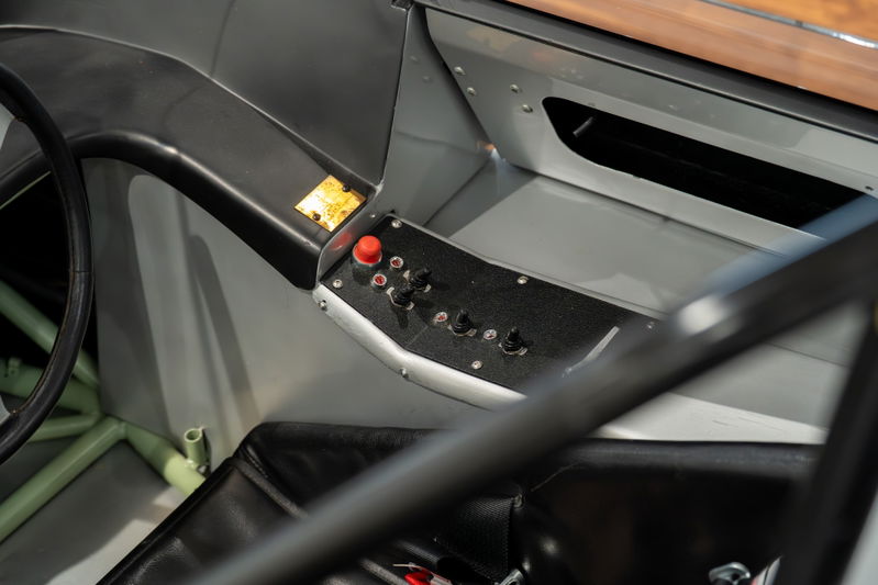 Close-up interior view of a 1964 Elva Porsche 4-Cam with toggle switches and a red button on the dash.