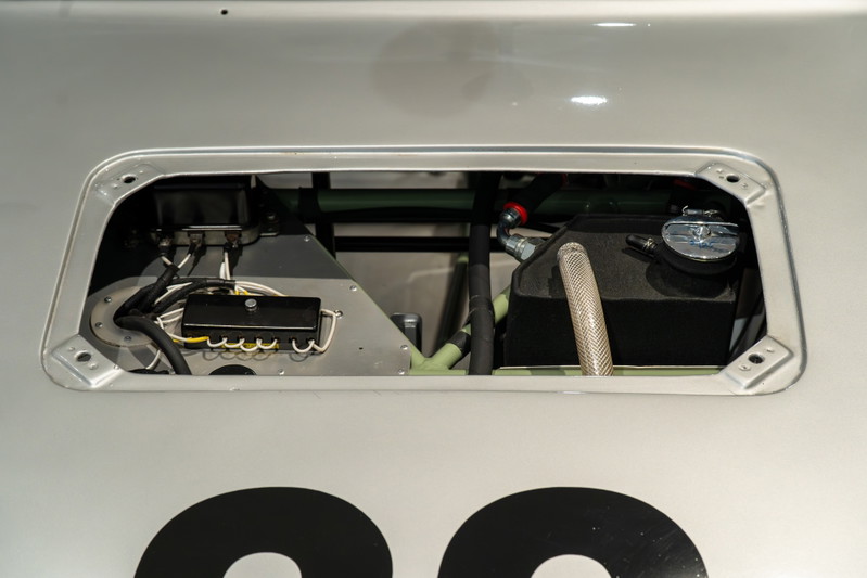 1964 Elva Porsche 4-Cam with a silver finish. Close-up on the engine bay with fuel tank and electrical components.