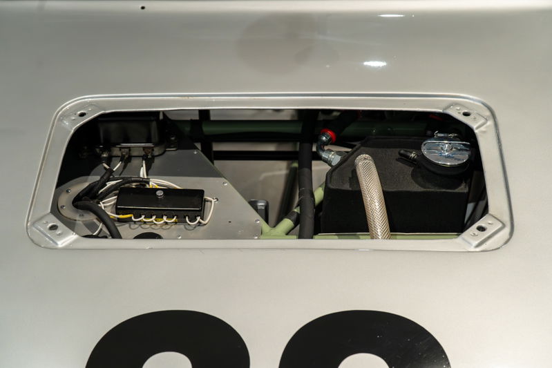 1964 Elva Porsche 4-Cam with a silver finish. Close-up on the engine bay with fuel tank and electrical components.