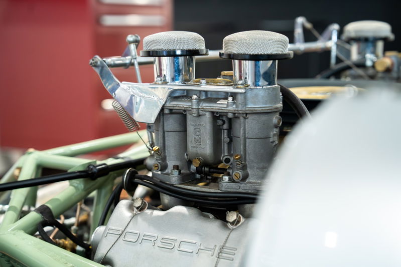 Close-up of a vintage 1964 Elva Porsche 4-cam engine with dual carburetors and air filters.