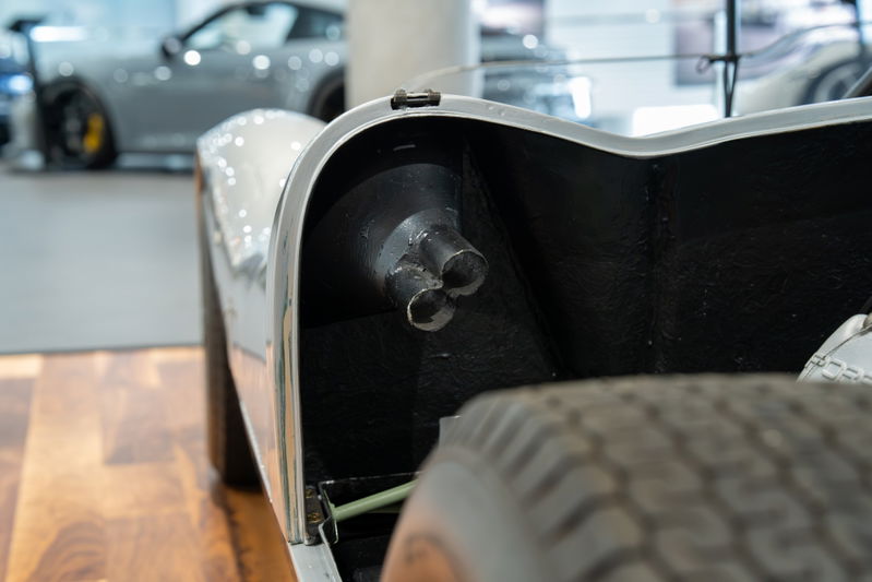 Close-up of a 1964 Elva Porsche 4-Cam's triple exhaust pipes.