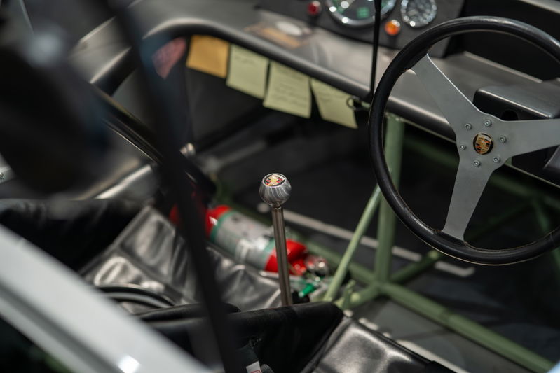 1964 Elva Porsche 4-Cam interior: racing steering wheel, metal shift knob, fire extinguisher.