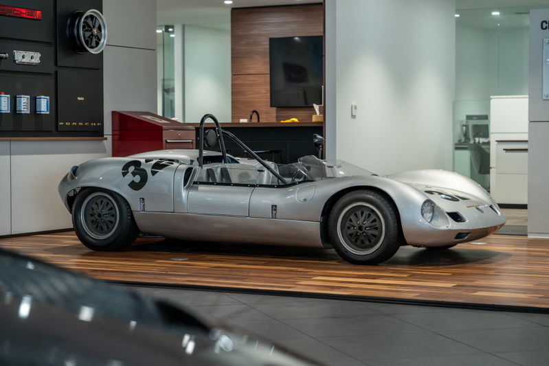 Silver 1964 Elva Porsche 4-Cam race car with number 33 livery and black rims.