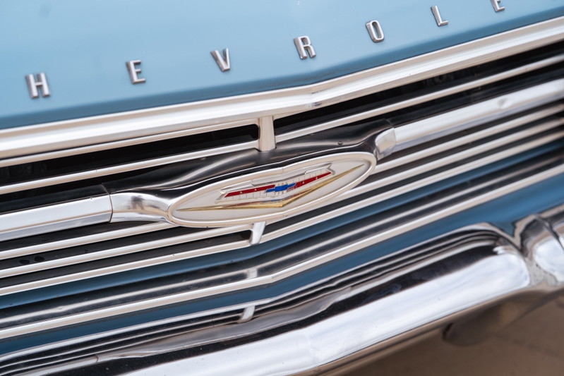 Close up of a blue 1963 Chevrolet Impala low rider grille and emblem.