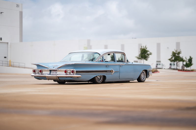 1960 light blue Chevrolet Impala lowrider with chrome rims and classic fins.