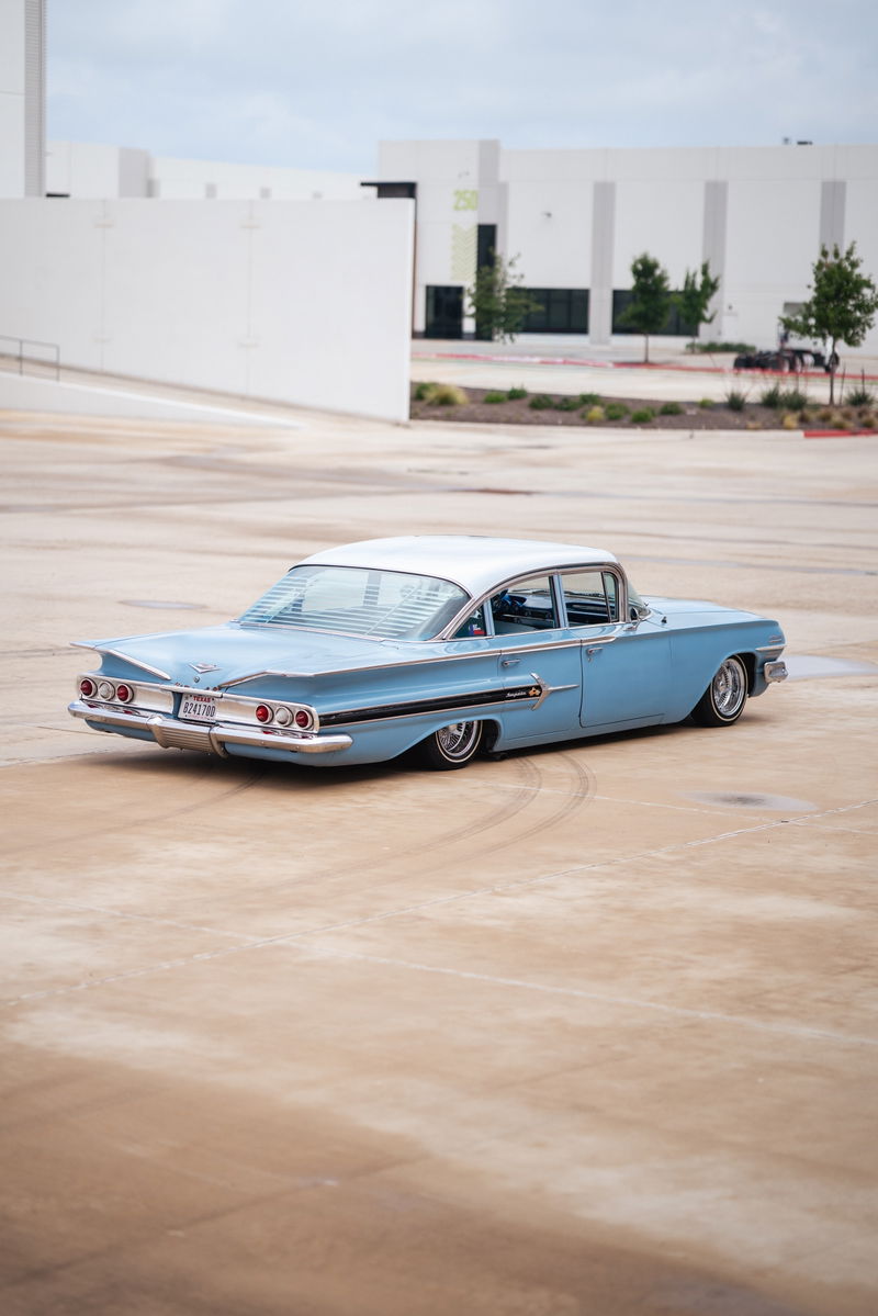 Low-rider 1959 blue Chevrolet Impala with chrome rims and classic fins.