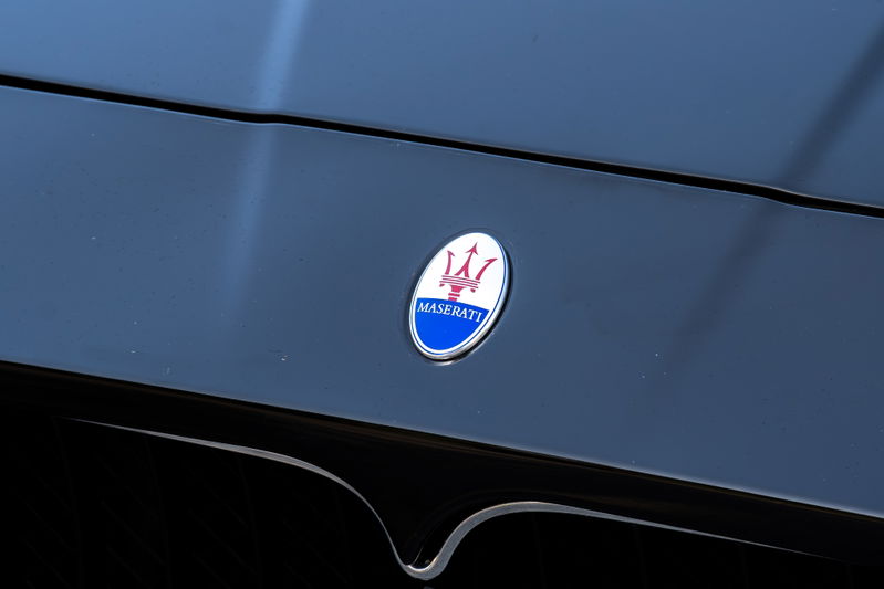 Close-up of a Maserati GranTurismo's badge on its black hood.