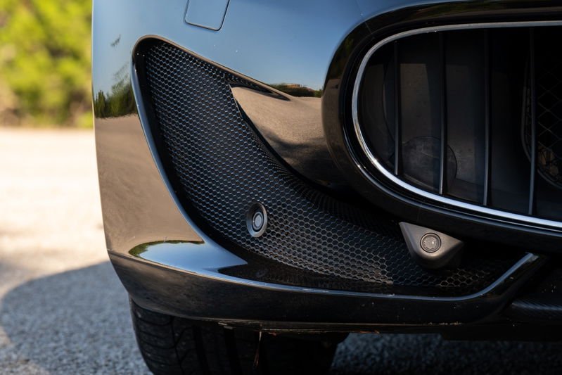 Black 2016 Maserati GranTurismo front bumper with parking sensors and honeycomb grille detail.