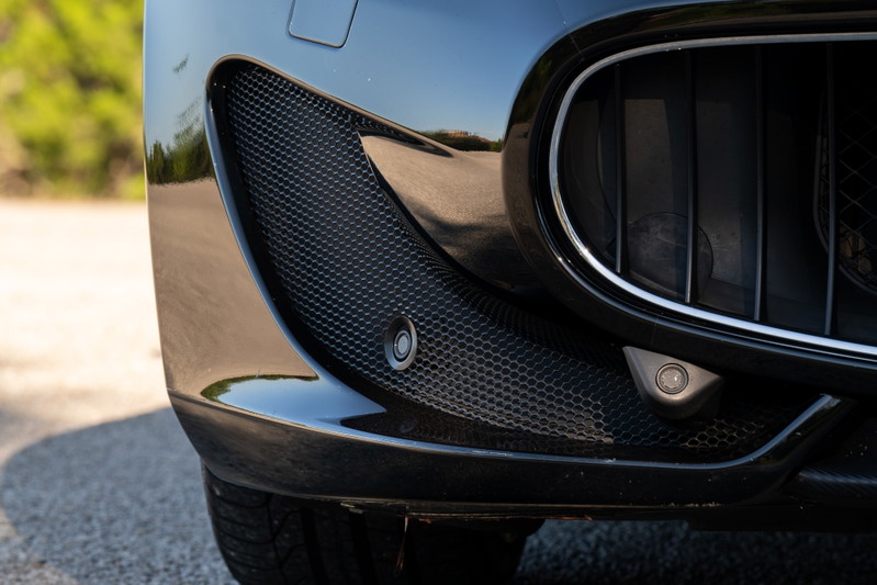 Black 2016 Maserati GranTurismo front bumper with parking sensors and honeycomb grille detail.