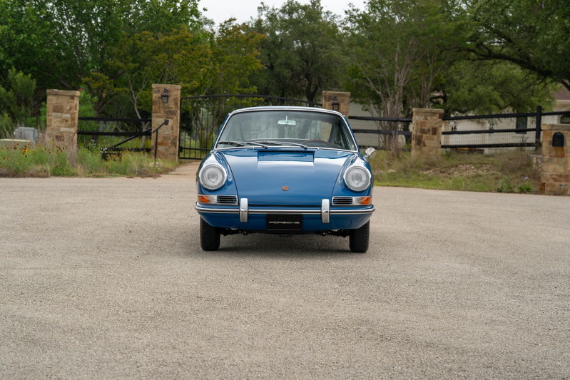 Front view of a classic blue 1965 Porsche 912 coupe with chrome trim.