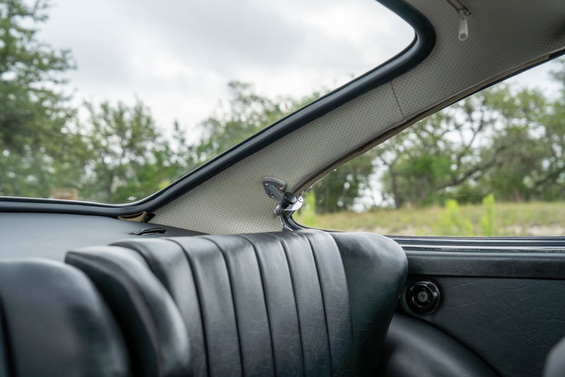 Close-up of the rear seat and perforated headliner trim of a 1965 blue Porsche 912 interior.