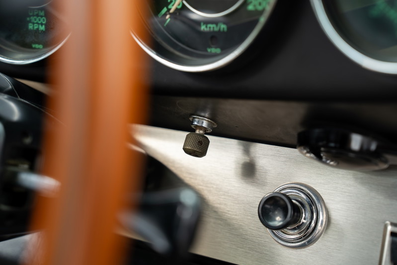 Classic 1965 blue Porsche 912 dashboard with vintage toggle switches and brushed aluminum trim.
