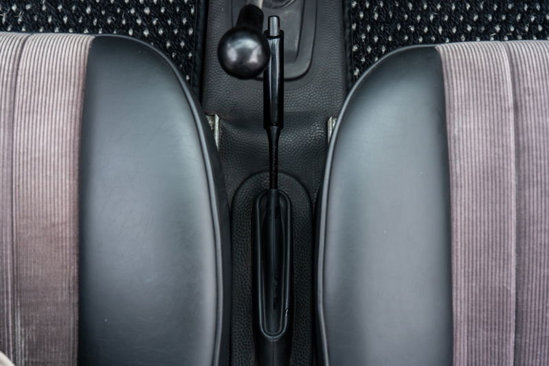 Interior of a 1965 Porsche 912 with cloth and vinyl seats and manual shifter.