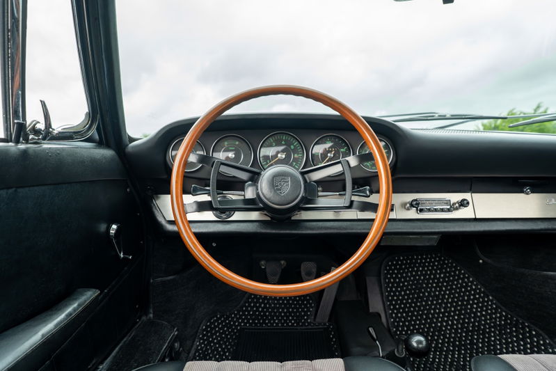 1965 blue Porsche 912 interior with a wood-rimmed steering wheel and classic gauges.