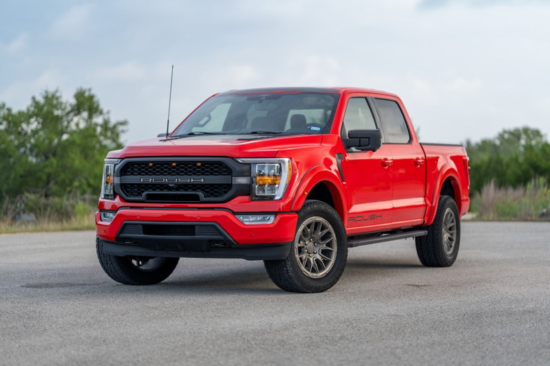 Red 2022 Ford F-150 Roush pickup truck with black grille, aggressive front bumper, and custom rims.