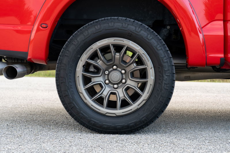 Red 2022 Ford F-150 Roush with gray multi-spoke rims and all-terrain tires.