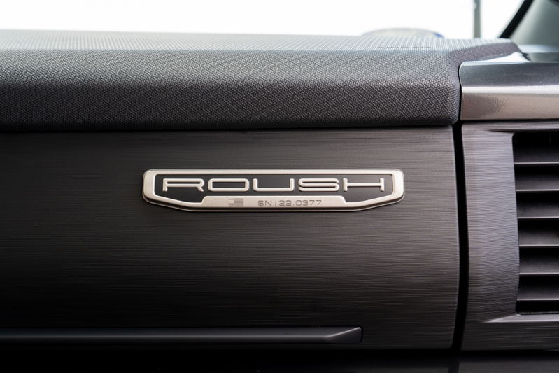 Close-up of the Roush badge on the dashboard of a 2022 red Ford F-150.