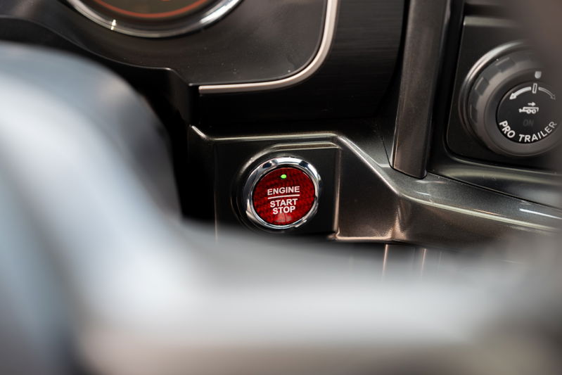 Close-up of the red 2022 Ford F-150 Roush start/stop button and Pro Trailer knob.