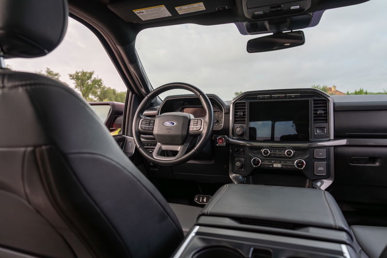 2022 Red Ford F-150 Roush interior with black leather seats and large touchscreen.