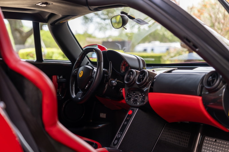 Red Ferrari Enzo interior with carbon fiber trim and racing seats.