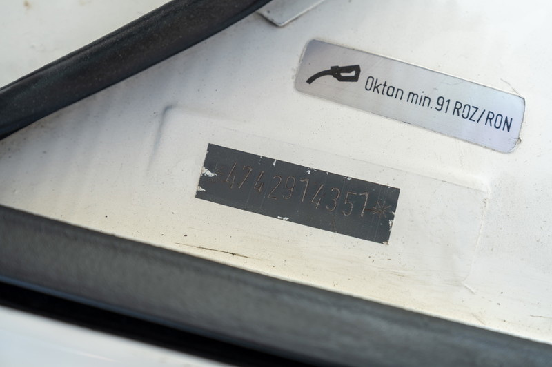 Close-up of a 1974 Porsche 914 VIN plate and fuel requirement sticker.