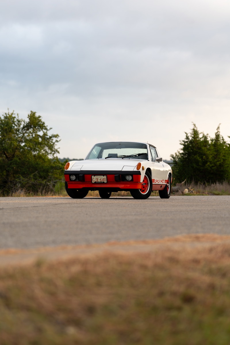 White 1974 Porsche 914 Can-Am with orange trim and rally livery.