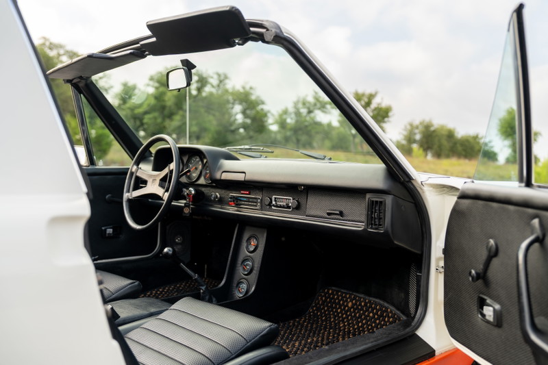 Interior view of a white 1974 Porsche 914 Can-Am LE with black leather seats.