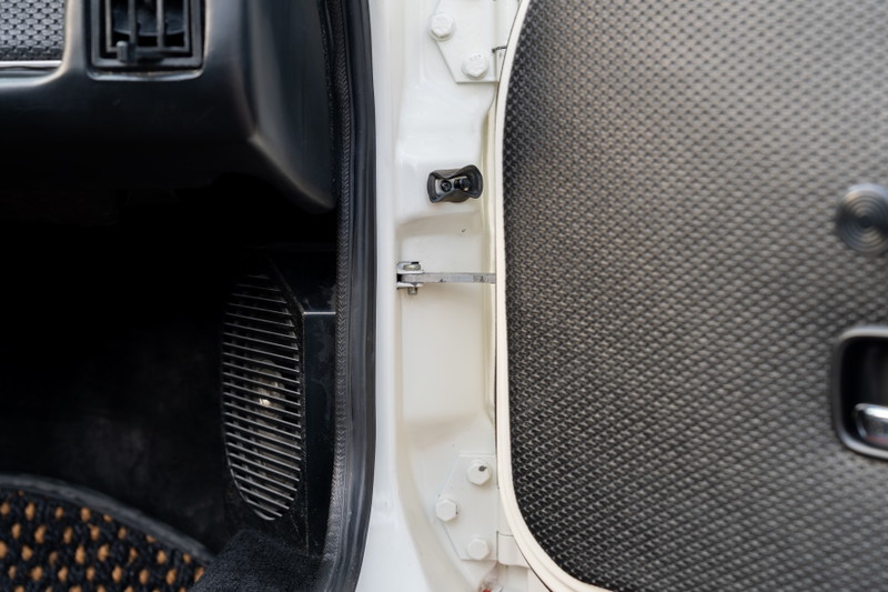 Interior of a white 1974 Porsche 914 with textured door panel and vent.
