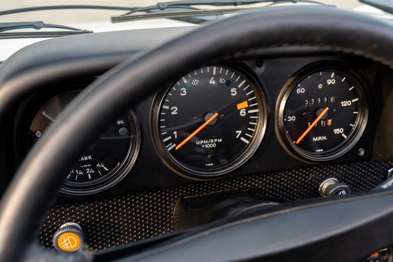 Close-up of 1974 Porsche 914 Can-Am LE dashboard with three gauges: fuel, tachometer, and speedometer.